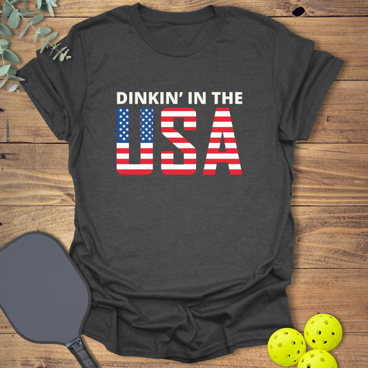 Patriotic pickleball t-shirt that says Dinkin' in the USA with flag design in heather grey