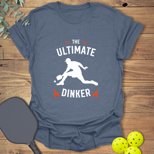 Unisex navy t-shirt with “The Ultimate Dinker” slogan and a graphic of a pickleball player. Funny pickleball shirt for fans of the soft pickleball game strategy.