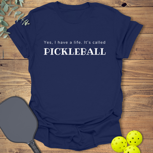 Navy unisex t-shirt with “Yes, I have a life. It’s called Pickleball” printed in white text. Funny pickleball shirt for players and fans.