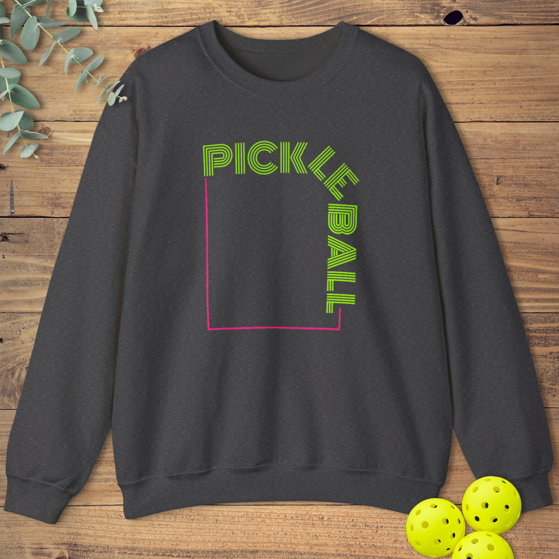 Heather grey sweatshirt featuring a modern geometric design with neon green outlined text. 'PICKLE' is horizontal at the top, and 'BALL' is vertical on the right side, forming a square outline with a pink/magenta line