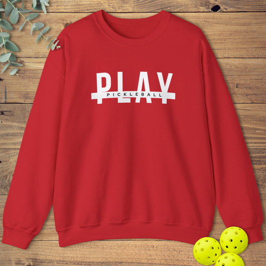 Red graphic pickleball sweatshirt with bold white text 'PLAY' split by a white horizontal bar, with smaller white text 'PICKLEBALL' centered on the bar.